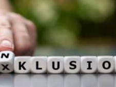 Foto zeigt aufgereihte W&uuml;rfel, die das Wort Inklusion bilden. Eine Hand dreht die Silbe "In", zum Vorschein kommt "Ex"